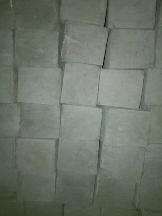Close-up of cement bags and gypsum boards stacked neatly at a construction site.