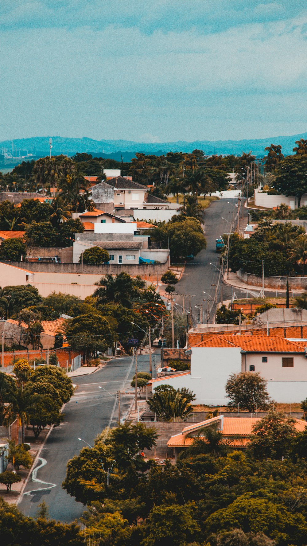 aerial photo of town with house and trees under blue sky