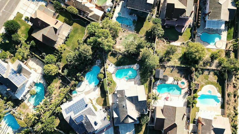 Aerial view of suburban homes with backyard pools, showing the kind of yard-and-pool lifestyle California movers often look for in Las Vegas and Henderson