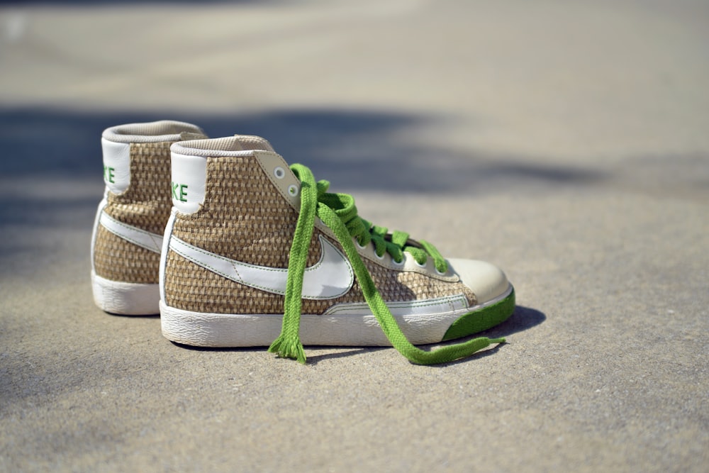 pair of brown-and-white Nike mid-rise sneakers on gray concrete pavement