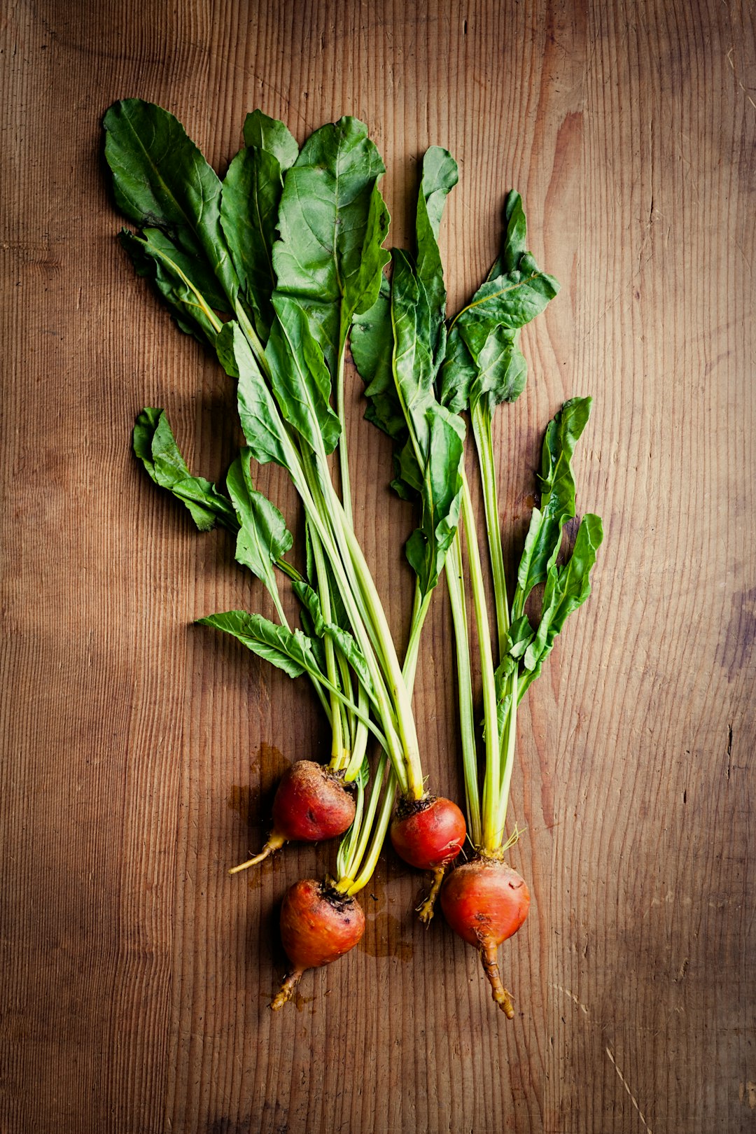 green and red vegetable on brown surface