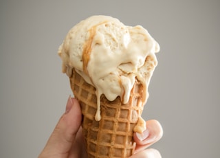 white ice cream on brown cone