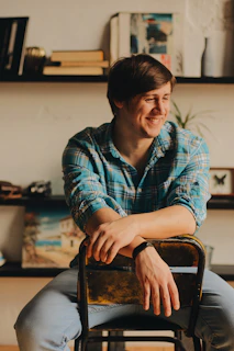 Host sitting comfortably with a friendly smile, surrounded by logistics books and travel memorabilia.
