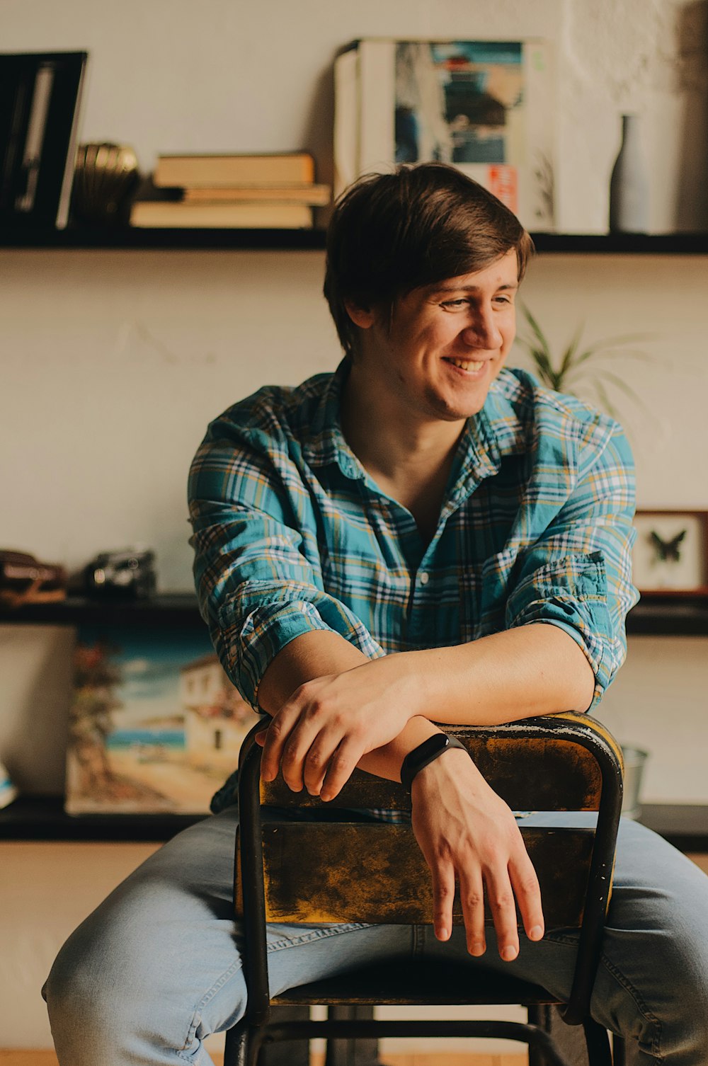 man in blue dress shirt sitting on chair and smiling