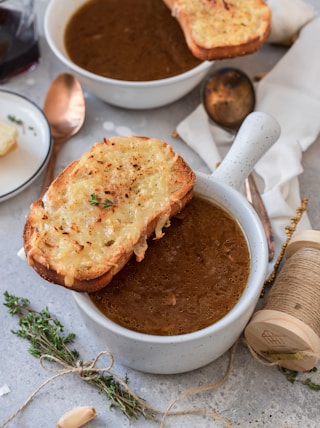 toasted breads on white ceramic bowl with brown soup