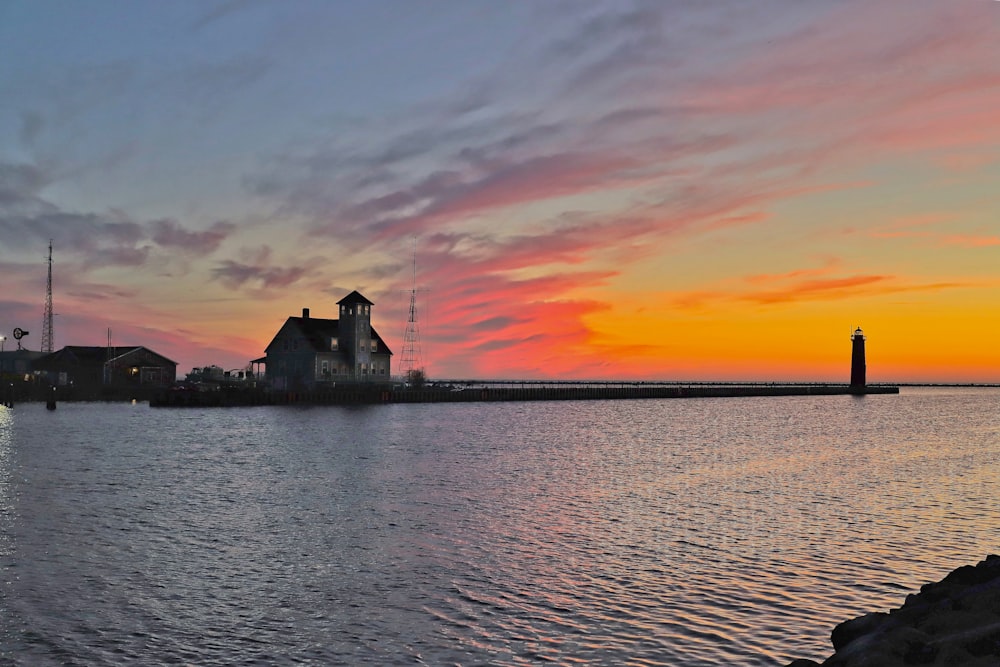 white house and wooden dock on body of water