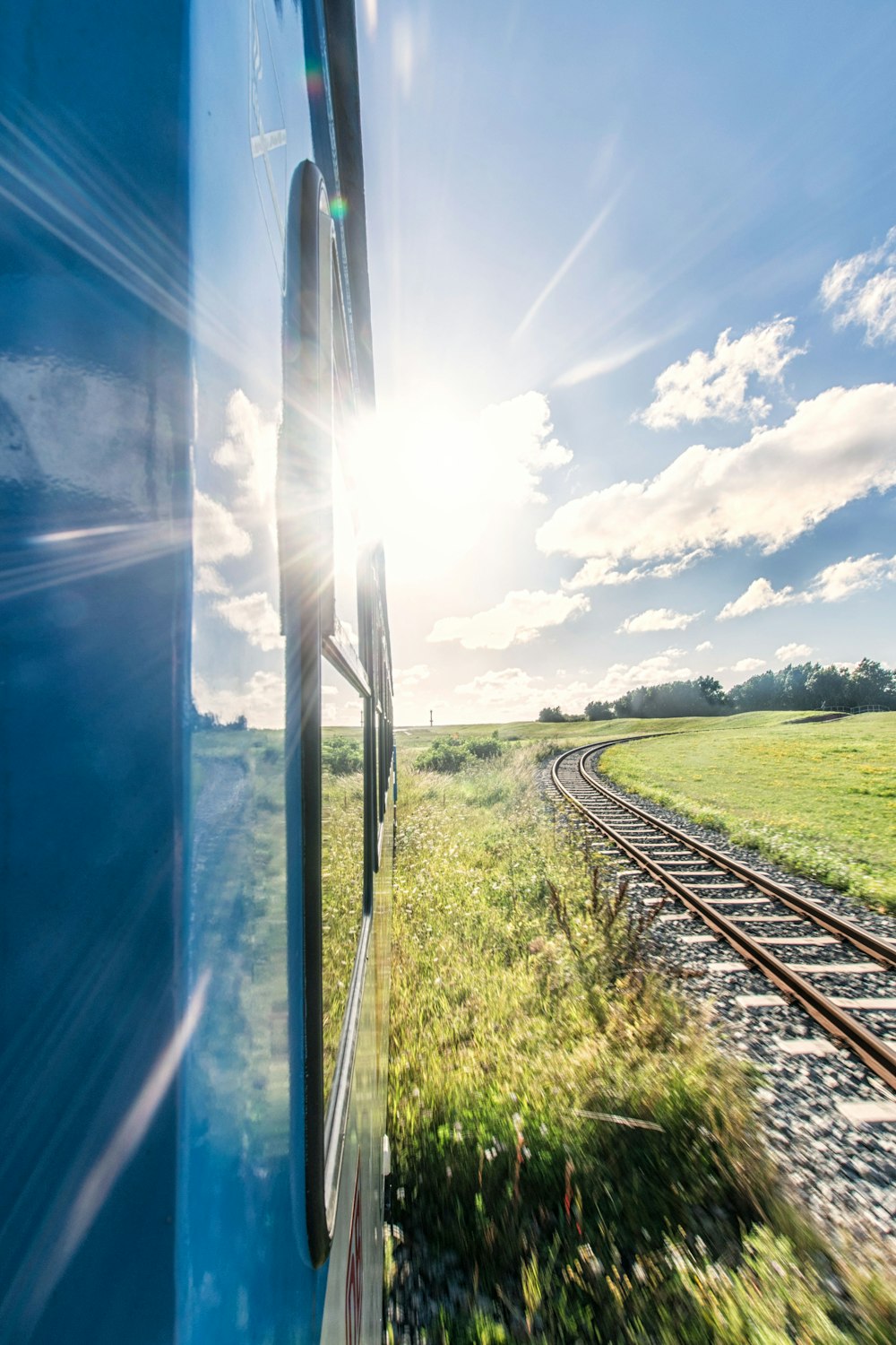 blue train beside train track at daytime