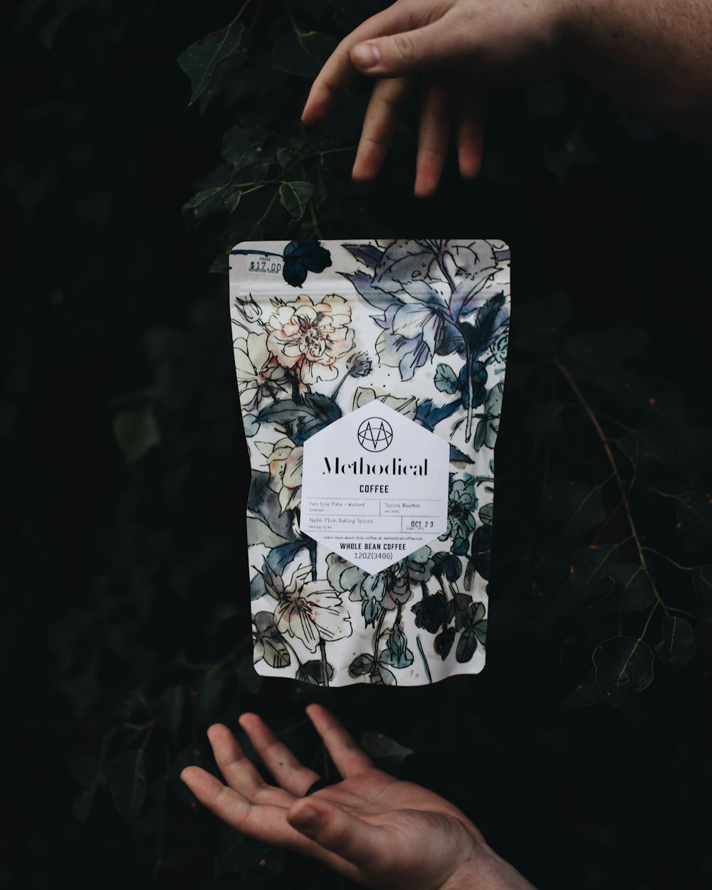 a person holding up a bag with flowers on it