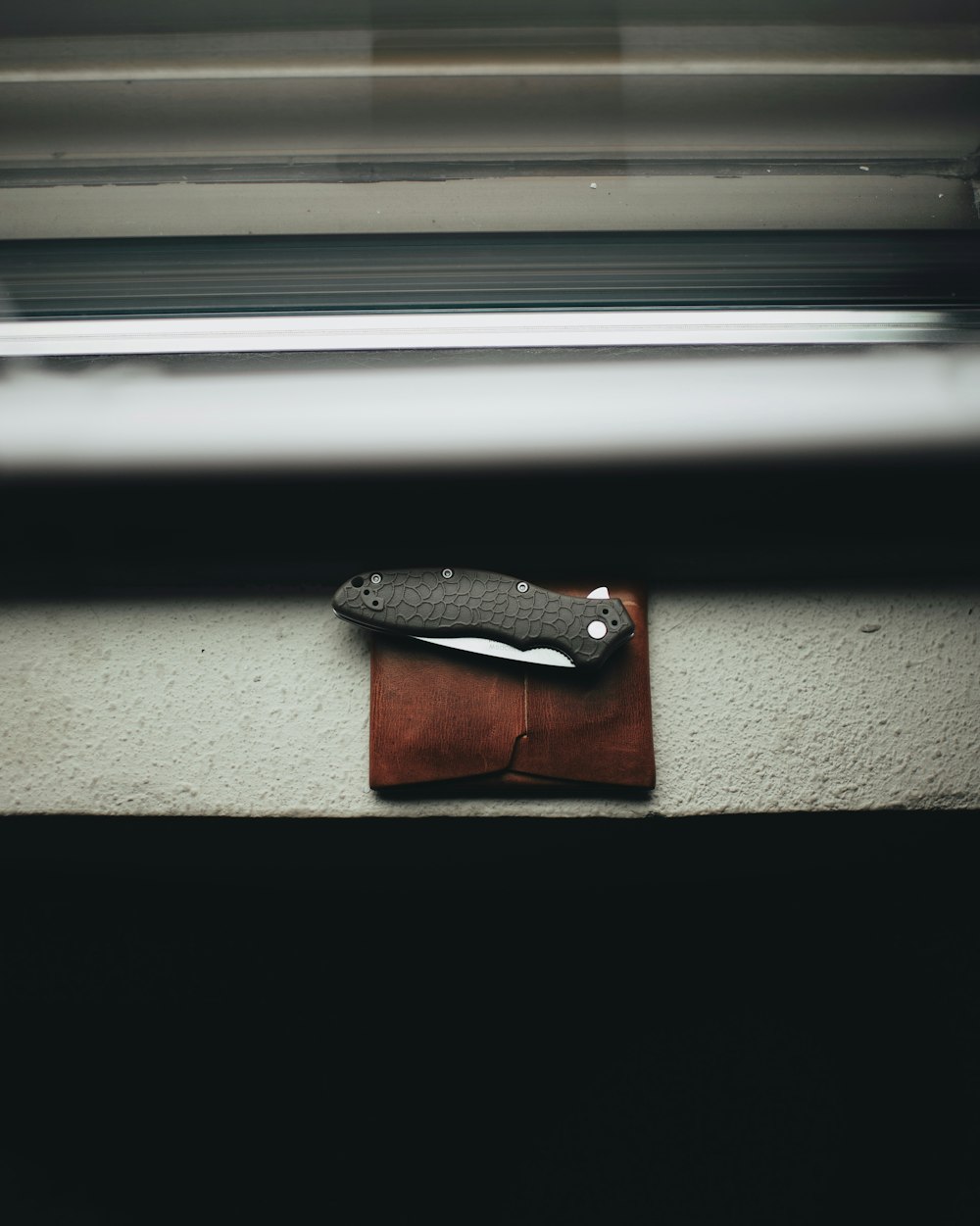 black handled pocketknife on brown leather case