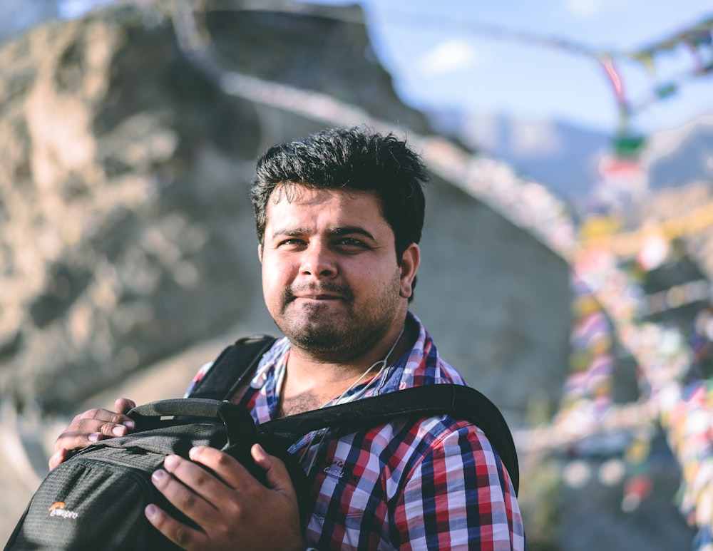 man carrying backpack in selective focus photography