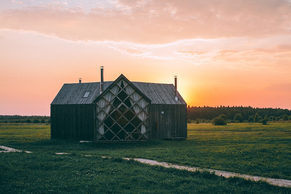 gray wooden house on green field