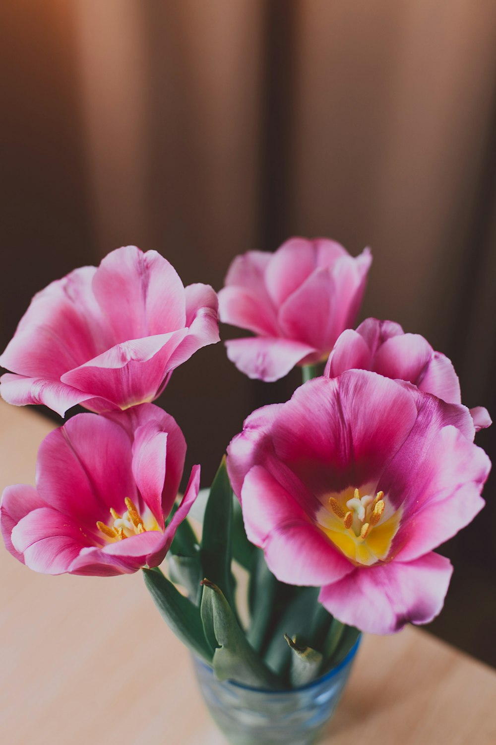 Flores de pétalos rojos y rosados en un vaso transparente