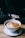 Close-up of a steaming cup of coffee on a wooden table with natural light.