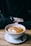 A close-up of a stylish tumbler filled with steaming coffee on a wooden table.