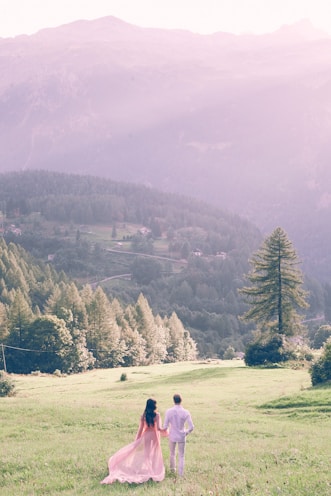 A romantic photo of Giovanna and Arthur holding hands in a sunlit field at Fazenda Pingo d'Água.
