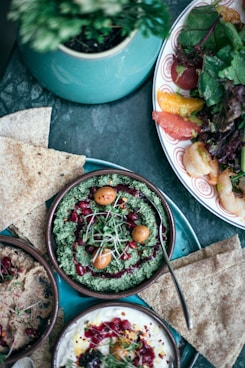 vegetable dish with spoon in bowl beside other dishes all on tray