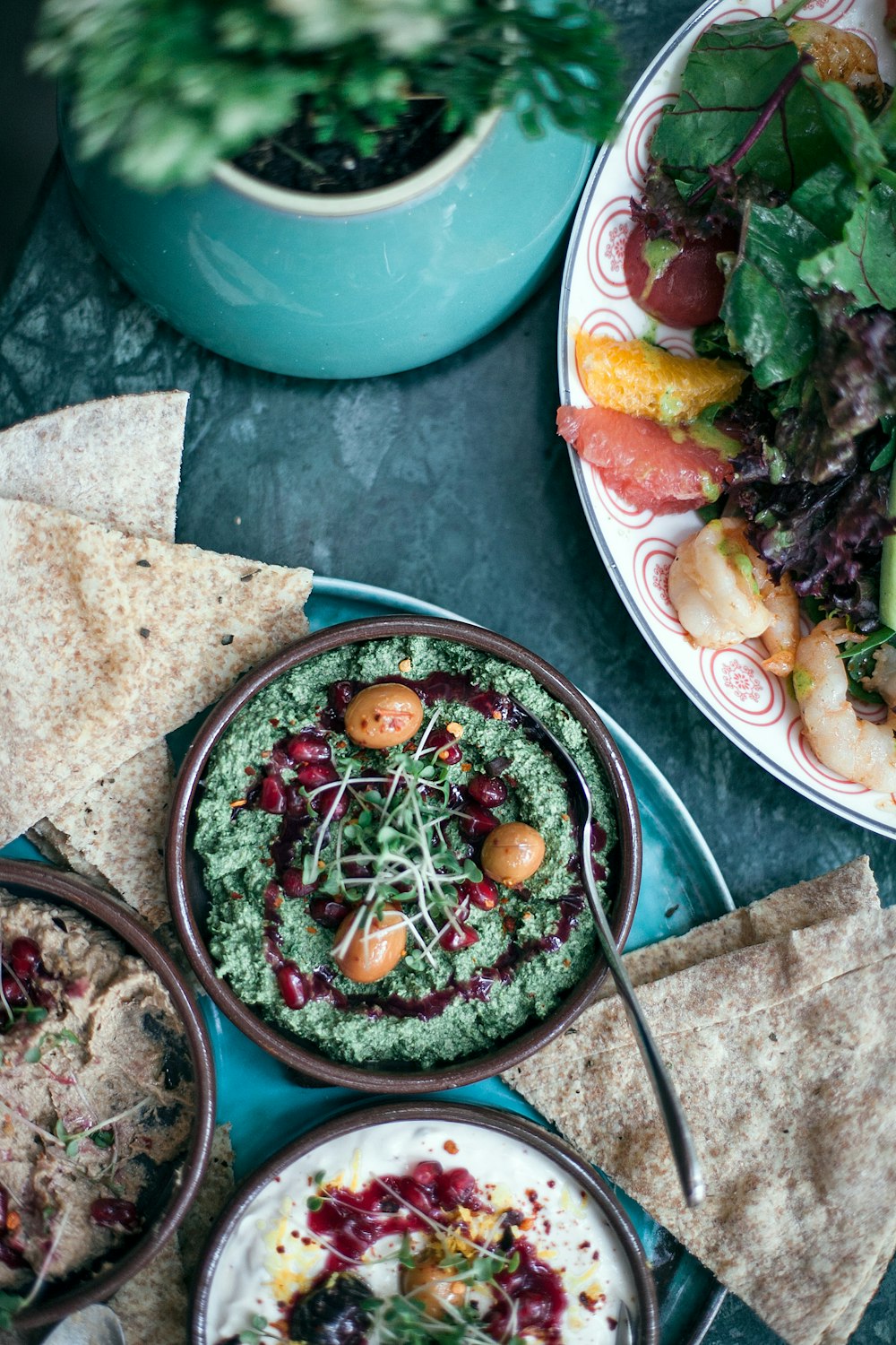 vegetable dish with spoon in bowl beside other dishes all on tray