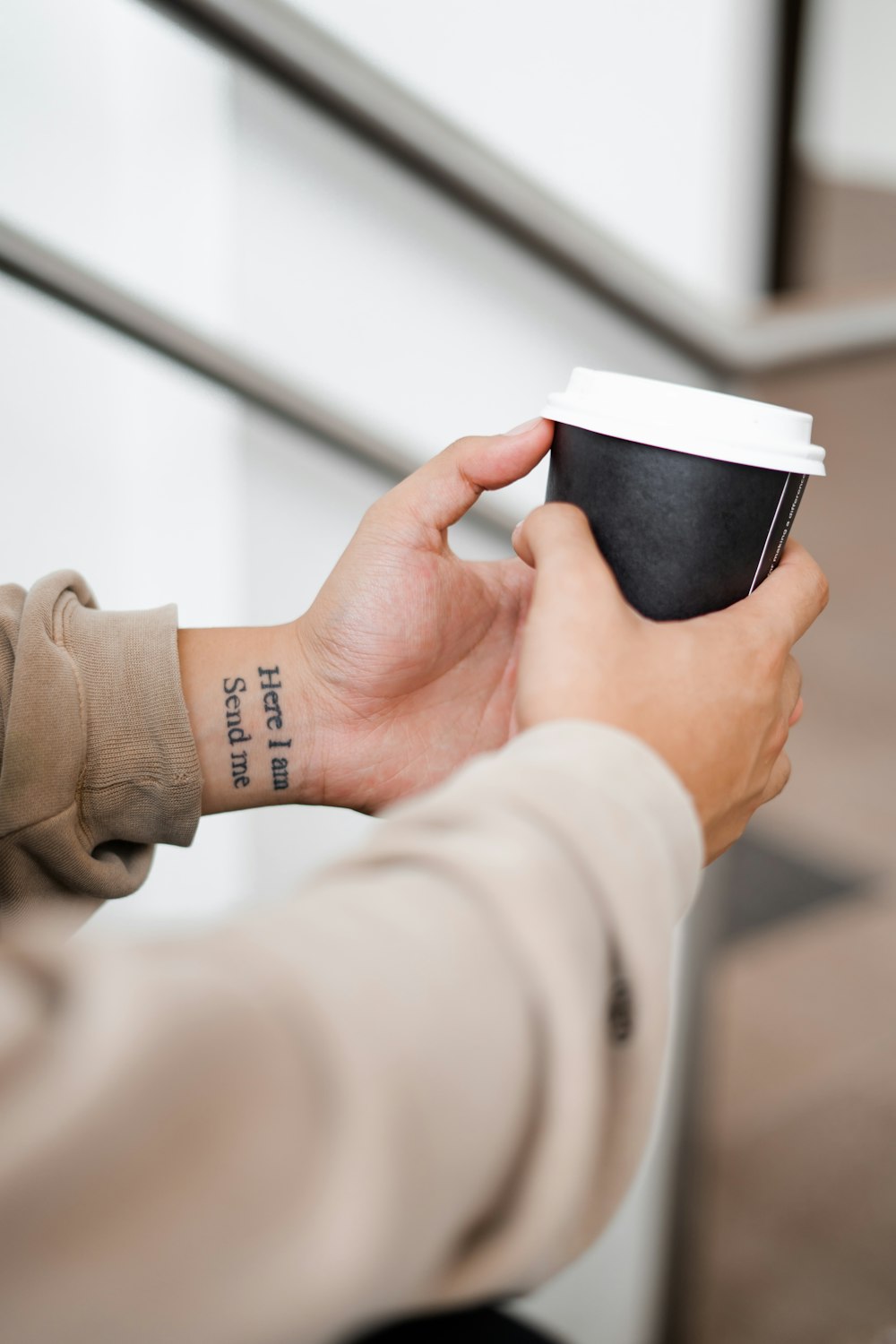 person holding black and white coffee cup