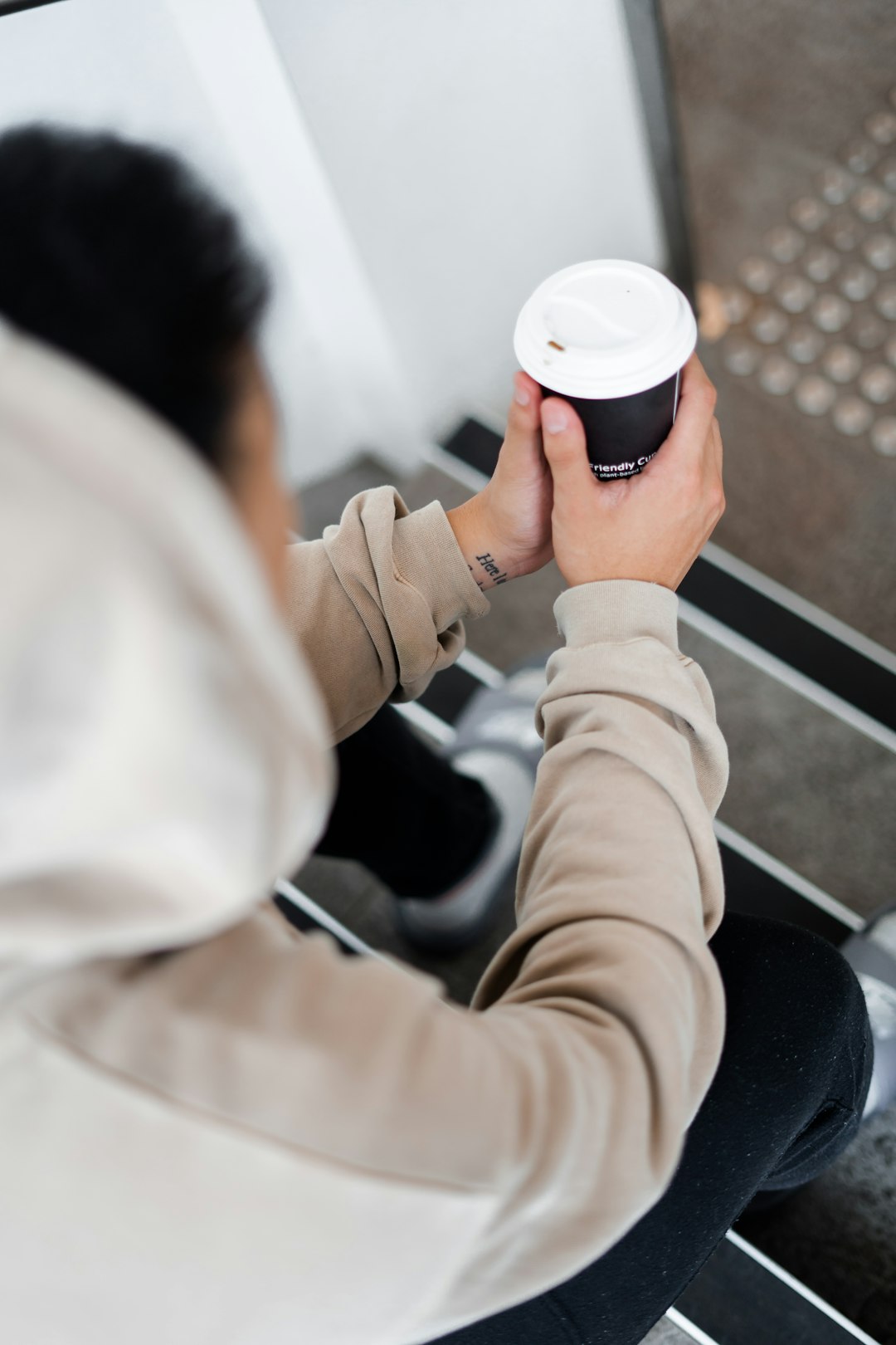 person holding black paper cup