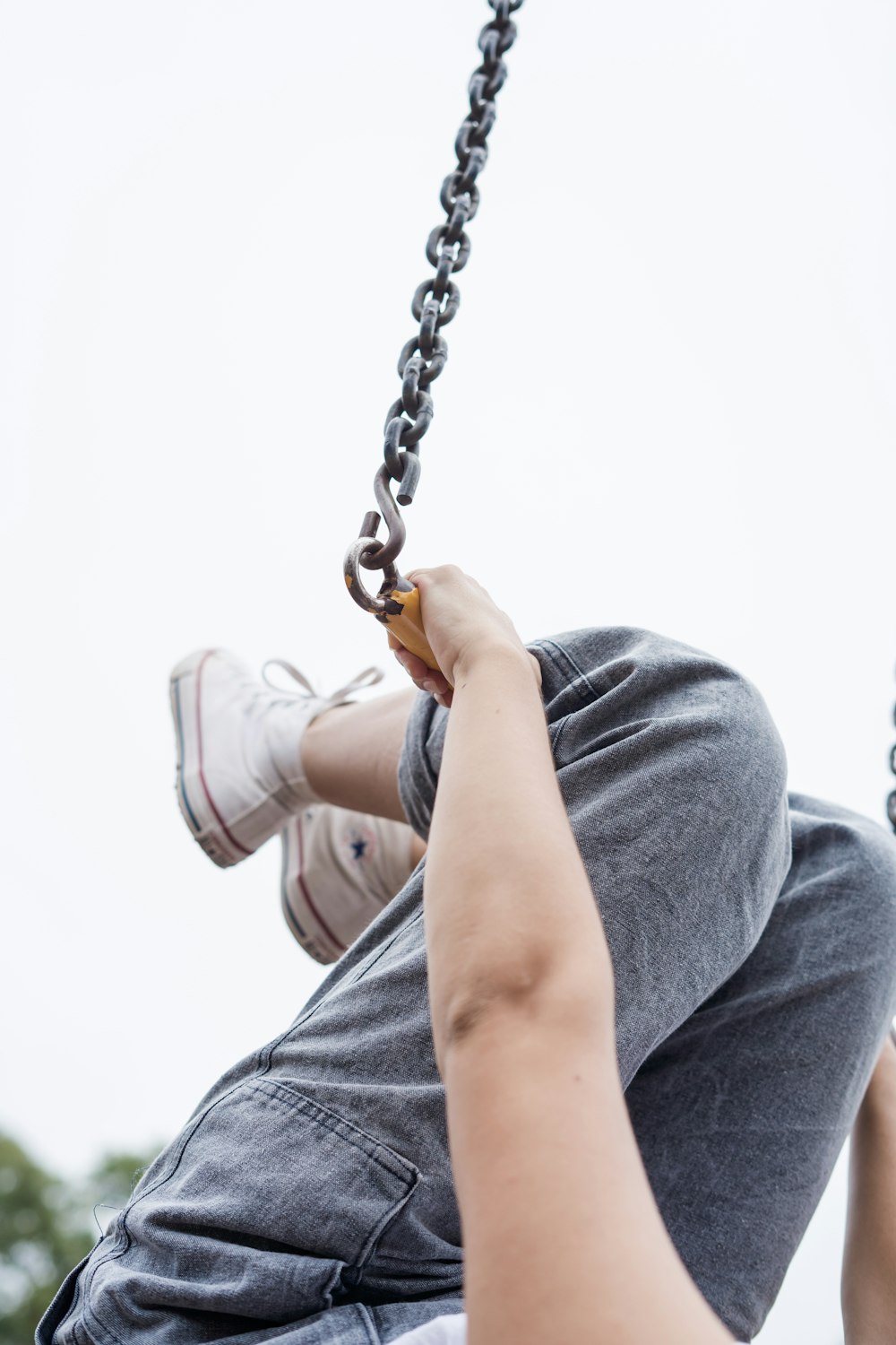 person holding tight on metal chain