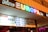 A cinema entrance with a colorful neon sign displaying the name 'Kino Europa'. Below the sign is a marquee listing movie titles in a foreign language.