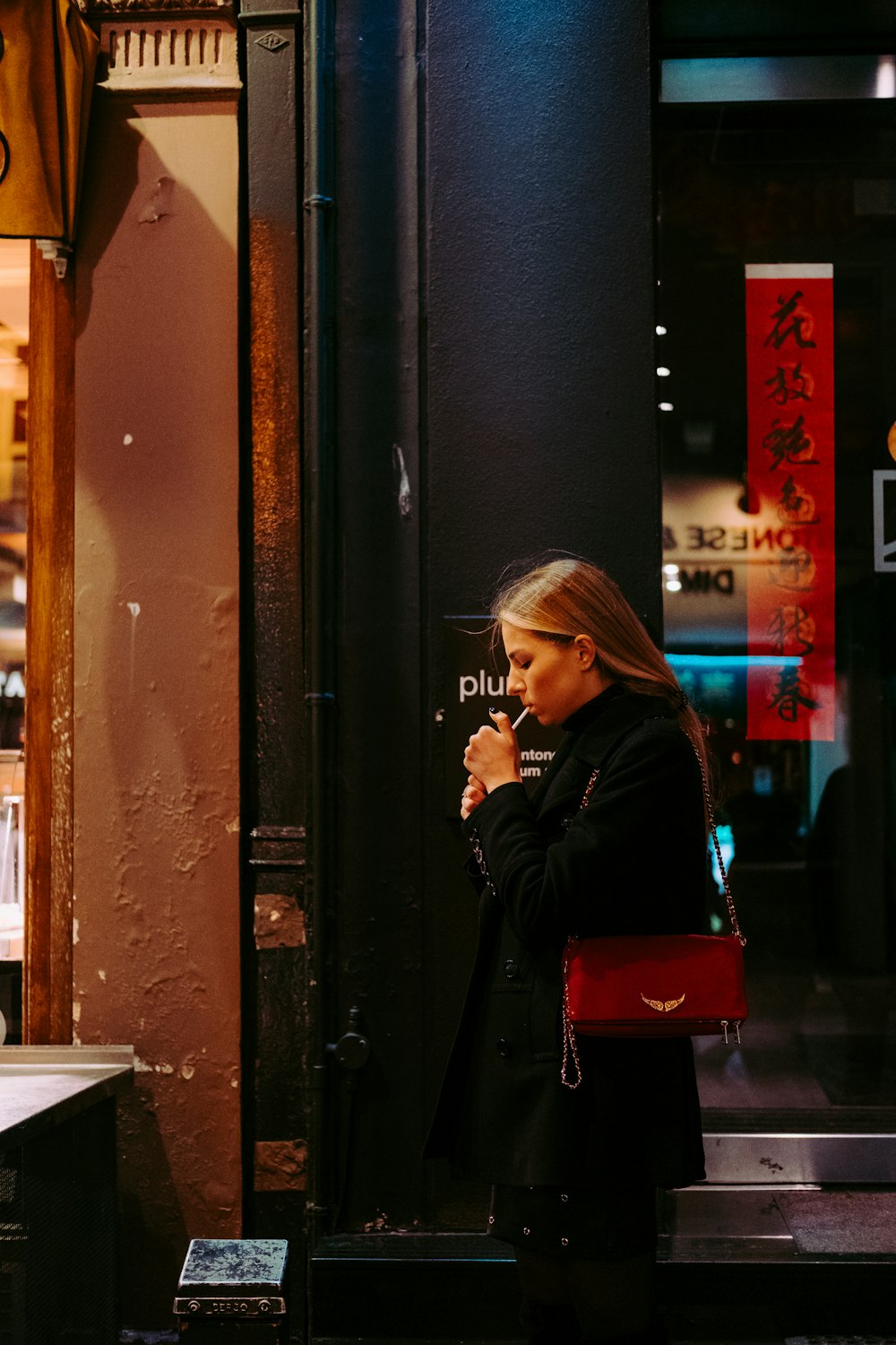 smoking woman beside sidewalk at night