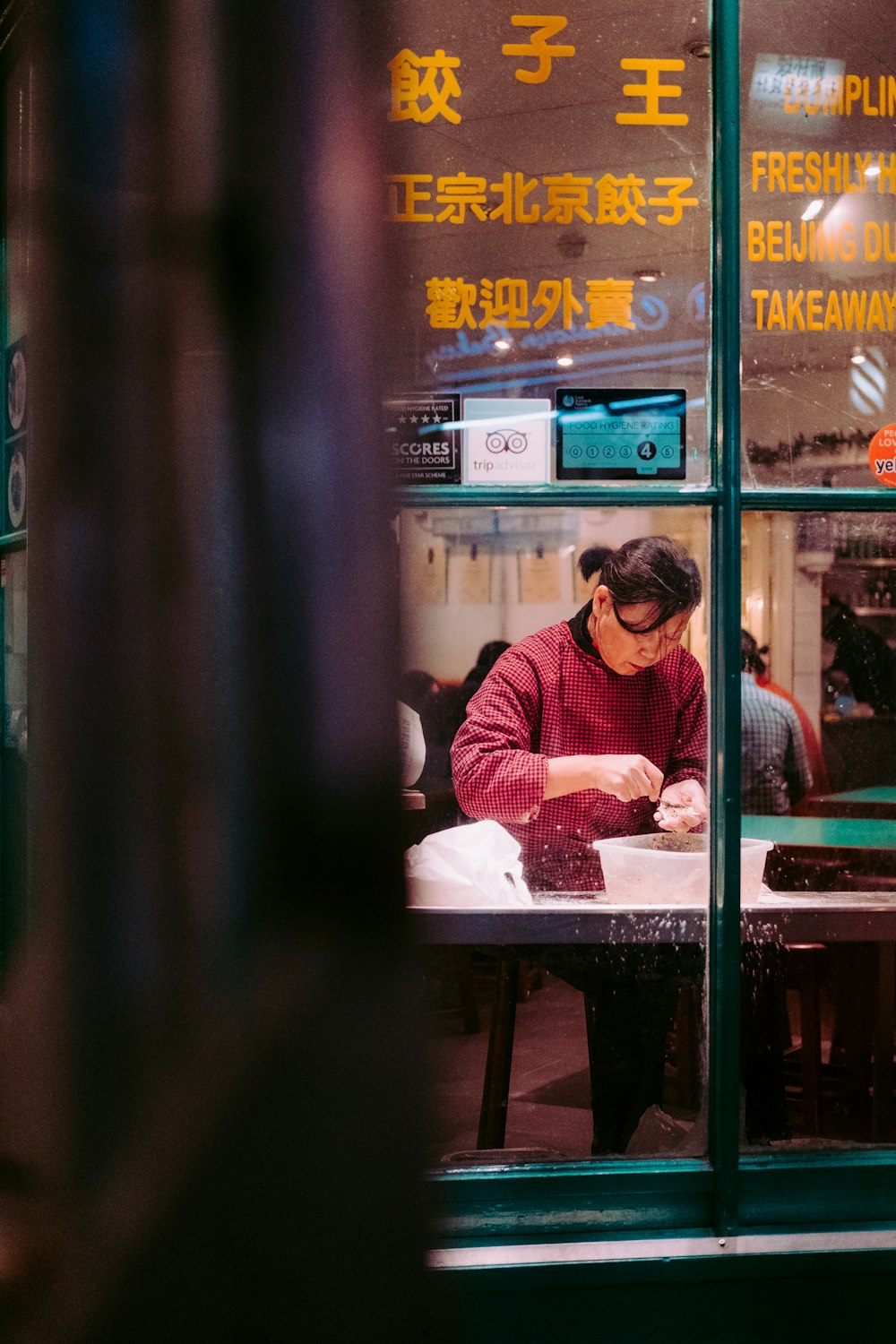 woman wearing red sweat shirt sitting beside table