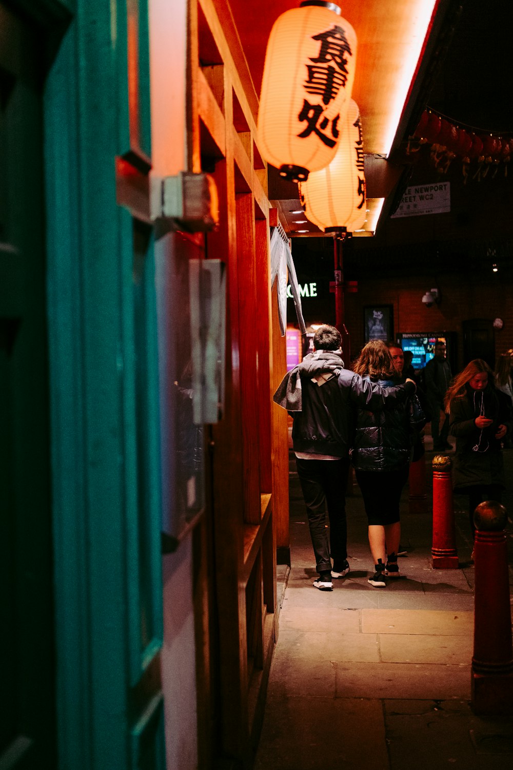 man and woman walking on sidewalk at night