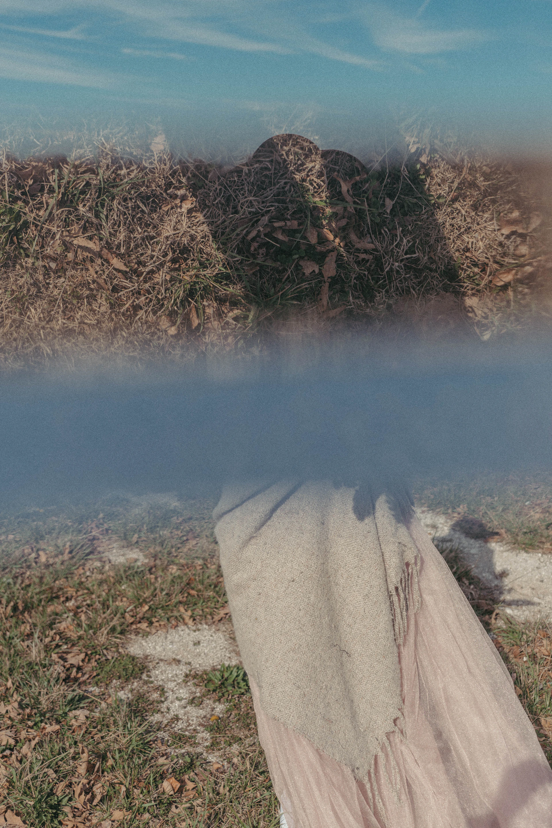 a blanket is laying on the ground in the grass