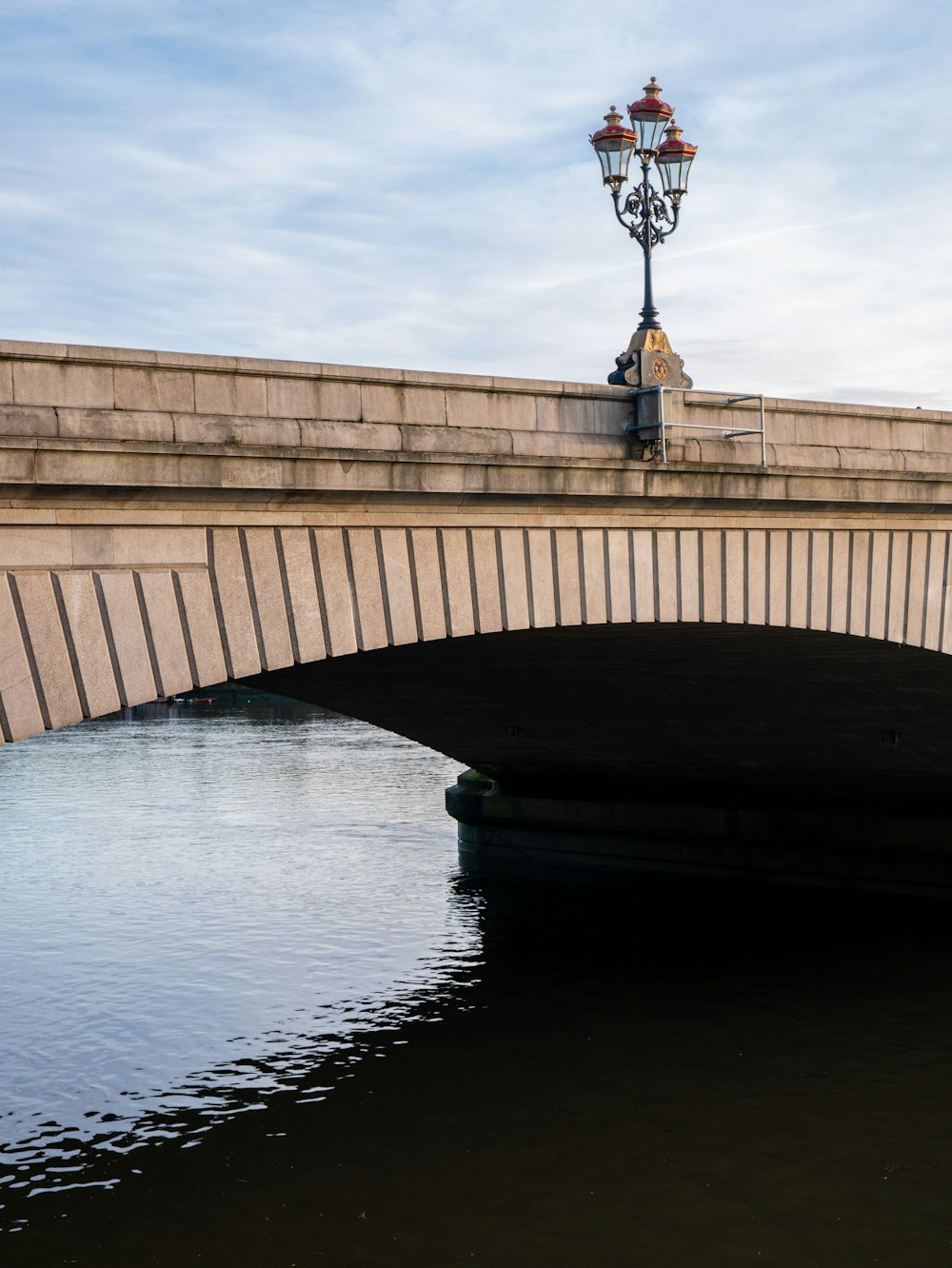 gray concrete bridge across calm water