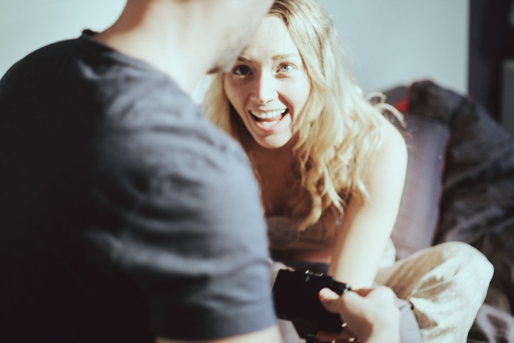 woman talking to man near white painted wall