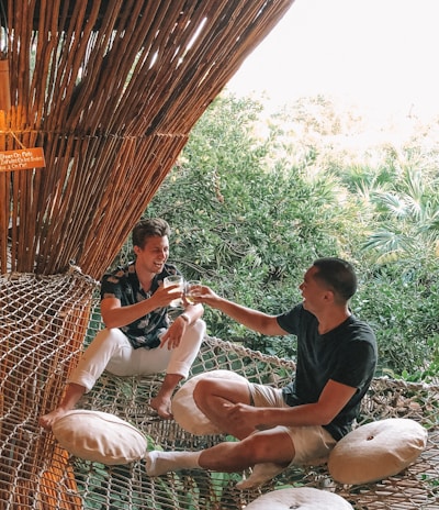 man in black crew neck t-shirt sitting on brown wicker chair