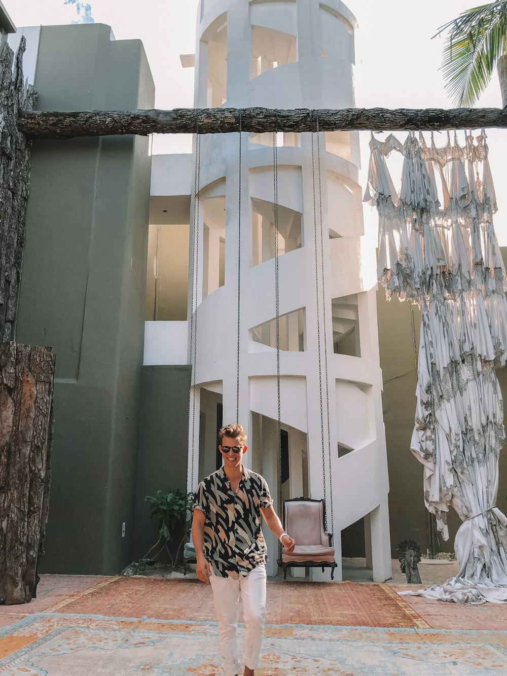 woman in black and white floral dress standing beside white concrete building during daytime