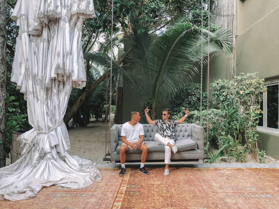 two men sitting on sofa while talking to each other