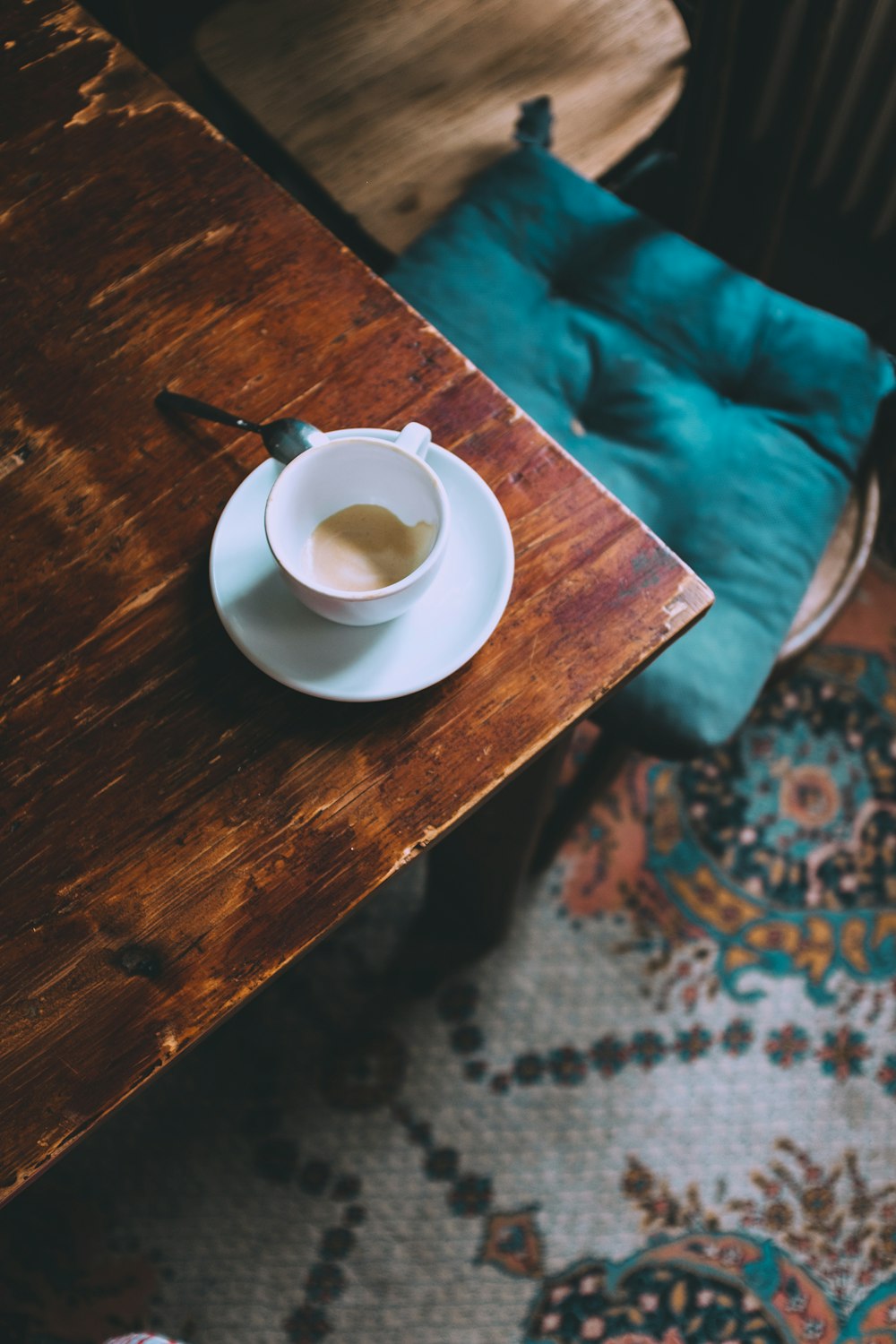 empty white ceramic mug and saucer on brown table