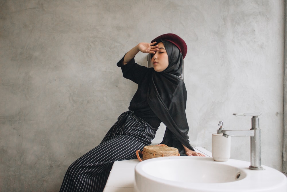 woman making post on white ceramic sink