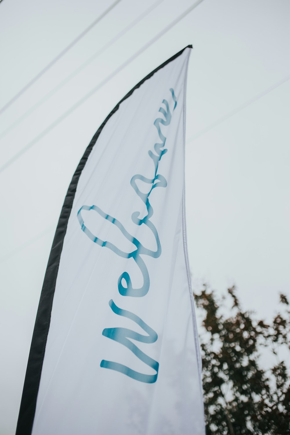 a white and blue flag with the word welcome on it