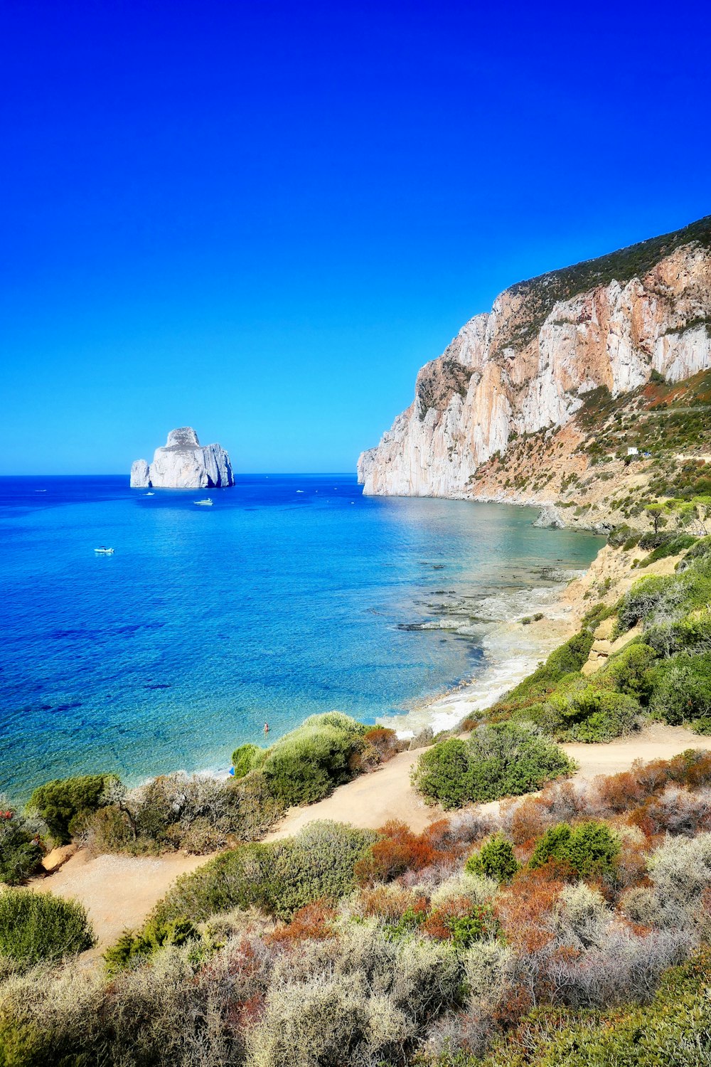 calm sea viewing beach cliff under blue skies