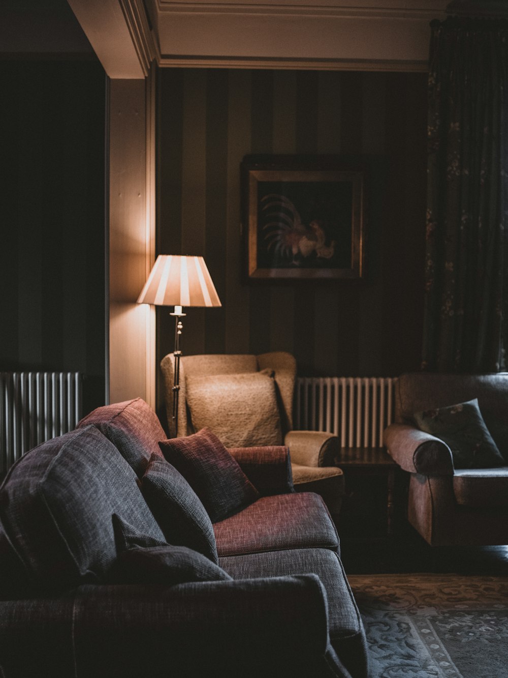 empty gray fabric sofas with turned on floor lamp