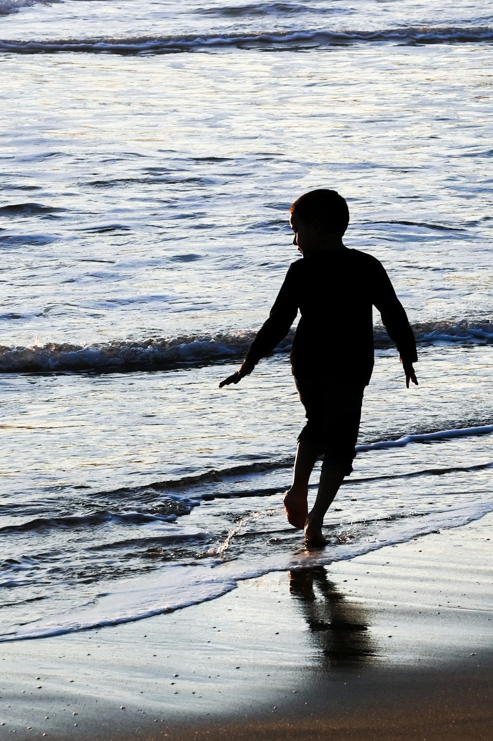 silhouette of child running on seashore