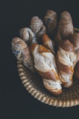 Artisan breads with crusty textures arranged in a wicker basket.