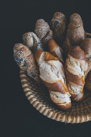 Close-up of freshly baked golden baguettes stacked in a rustic wooden basket.