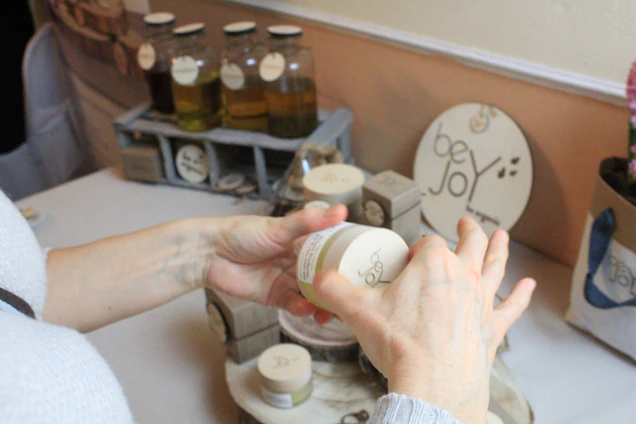 Close-up of artisan hands mixing natural ingredients for skincare products in a cozy workshop.