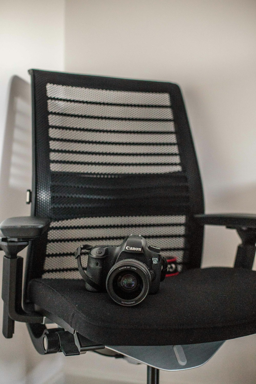 black Canon camera on rolling chair