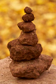 A serene corner with a terracotta-colored heat sack placed beside a small stack of natural stones.