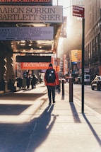 person walking on sidewalk during golden hour