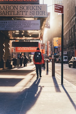 person walking on sidewalk during golden hour