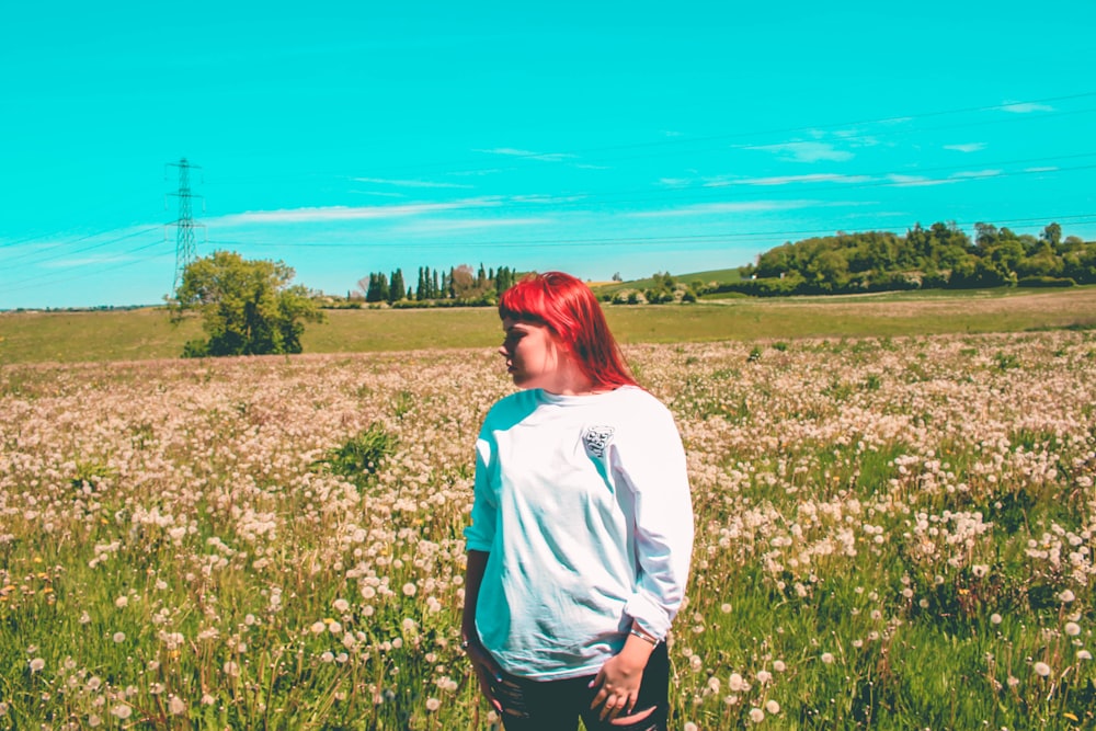 woman wearing sweater standing on flower field