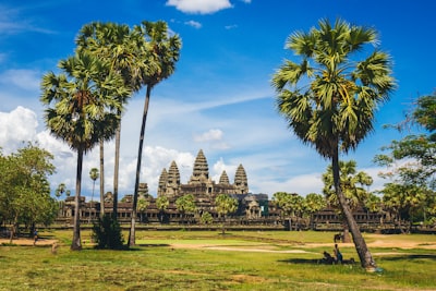 brown concrete building under white clouds cambodia teams background