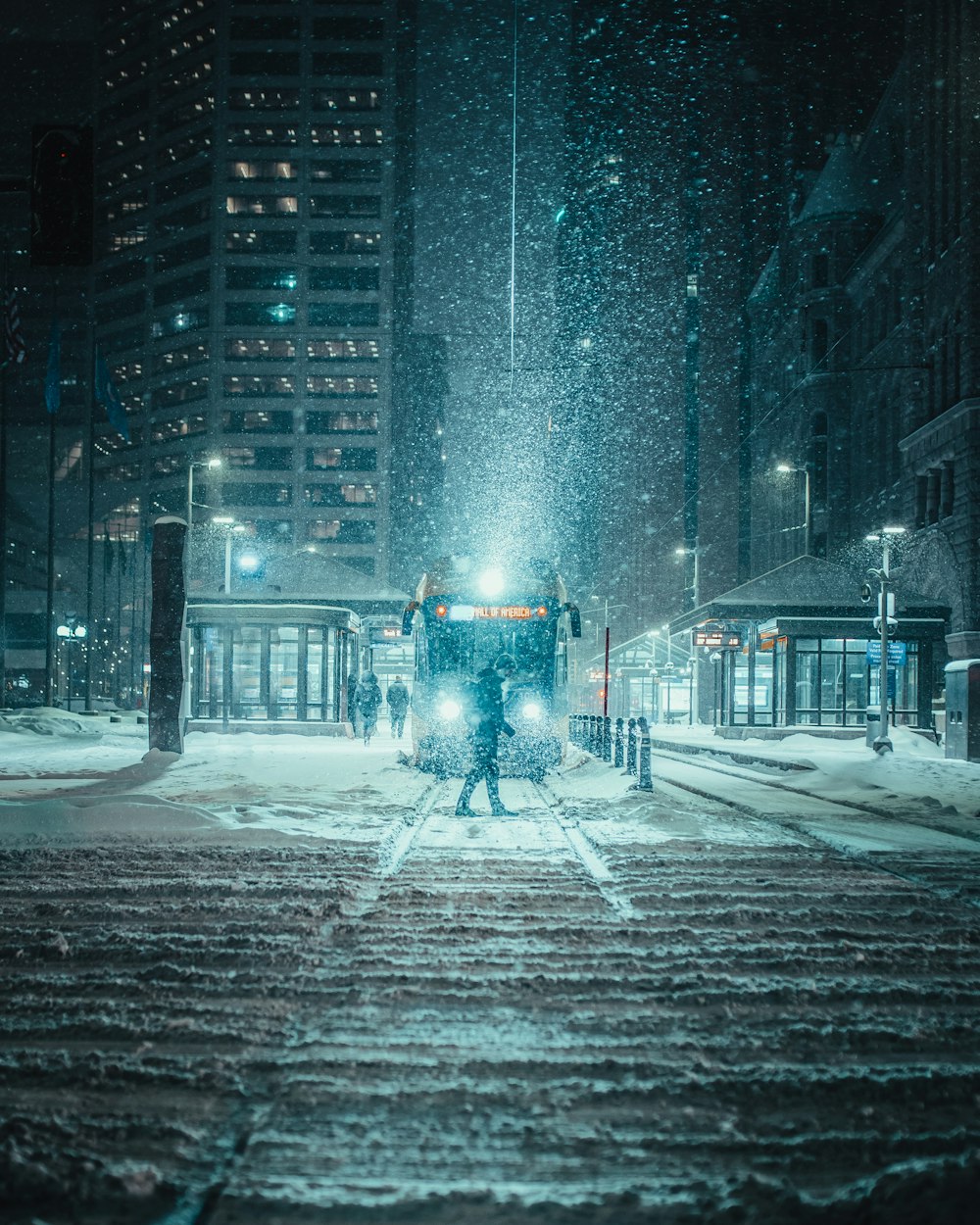 Person, die in der Winternacht auf einer schneebedeckten Straße steht